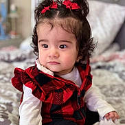 Abigail joined the competition — help win amazing prizes! bed, black_checkered, blanket, child, clothing, cozy, curly_hair, cute, expression, face, indoor, person, portrait, red_bows, red_vest, sitting, soft_lighting, toddler, white_shirt, young_child