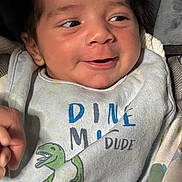 Draven joined the competition — help win amazing prizes! baby, infant, smile, face, clothing, bib, dinosaur, cute, happy, person, child, closeup, portrait, soft_lighting, indoors, baby_clothes, newborn, cozy, expression, wearing