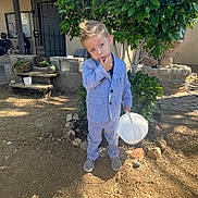 Lincoln is registered to the contest to win money with this photo: child, boy, suit, outdoor, yard, bucket, shoes, plant, tree, porch, house, dirt, sunlight, shadow, casual, thoughtful, posing, greenery, fashion, daytime