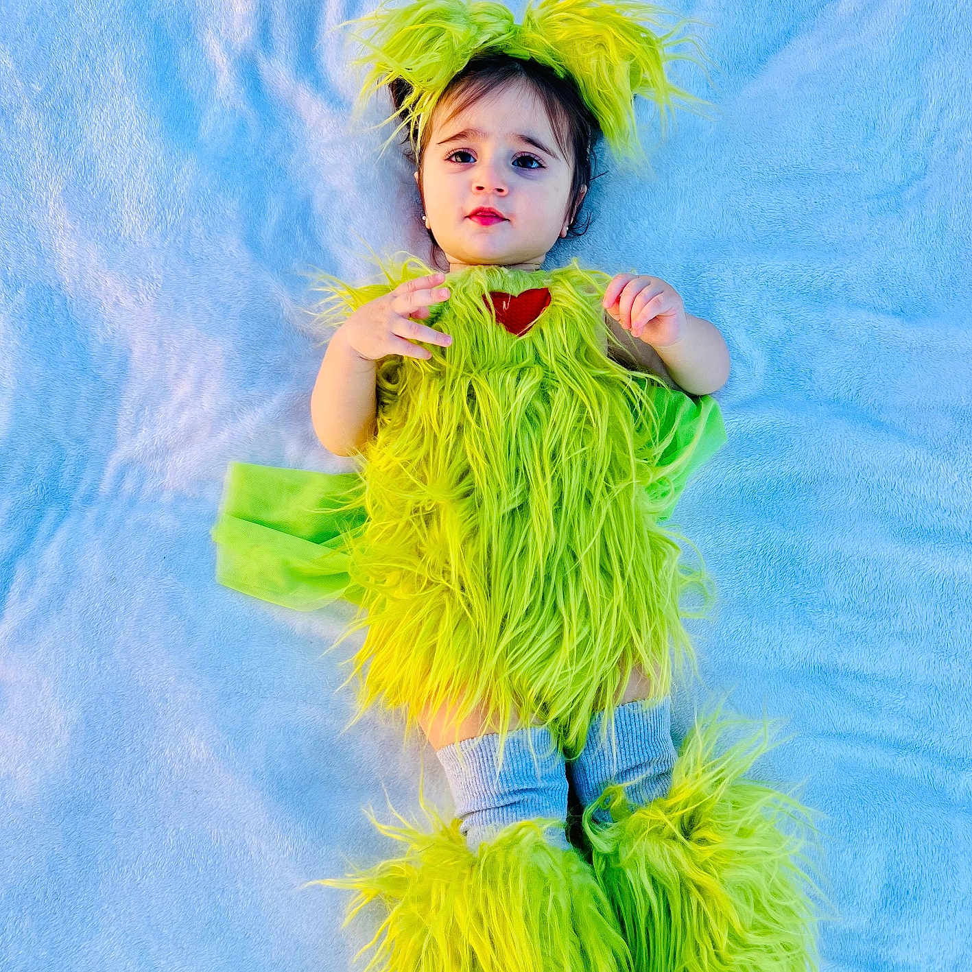 Teresa is registered to the contest to win money with this photo: baby, blanket, blue, child, costume, cozy, cute, eyes, feet, fuzzy, green, hands, headpiece, infant, leg_warmers, lying_down, portrait, smiling, soft_texture, young
