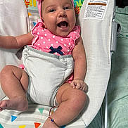 Lia joined the competition — help win amazing prizes! baby, infant, child, smiling, open_mouth, pink_bow, headband, polka_dots, pink_clothing, baby_seat, reclining, indoor, portrait, face, eyes, arms, legs, colorful, patterned_background, safe_sleeping_area