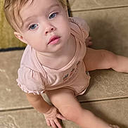 Payton is registered to the contest to win money with this photo: toddler, child, baby, sitting, floor, tile, blue_eyes, pink_clothing, curly_hair, indoor, portrait, cute, soft_lighting, hand, face, expression, casual, young, person, skin