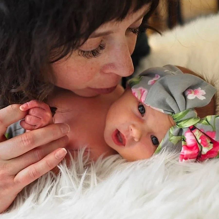 Saoirse is registered to the contest to win money with this photo: baby, cheek, child, comfort, eyelash, fashion_accessory, finger, fun, gesture, grass, happy, headpiece, headwear, jewellery, linens, lip, mouth, nose, person, petal