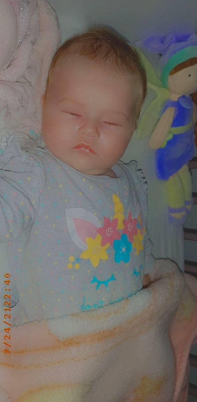 Yvana participe au concours pour gagner de l'argent avec cette photo : baby, baby_products, baby_toddler_clothing, cheek, child, eyelash, finger, hair, iris, linens, neck, pattern, person, pink, product, room, skin, sleeve, t_shirt, textile