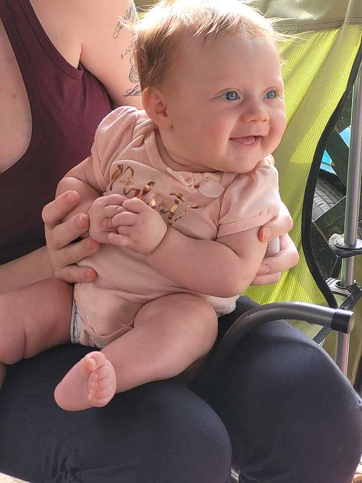 Adalynn is registered to the contest to win money with this photo: baby, baby_toddler_clothing, cheek, eye, finger, gesture, hairstyle, happy, head, human_body, iris, joint, joy, lap, leg, mouth, person, skin, smile, stomach