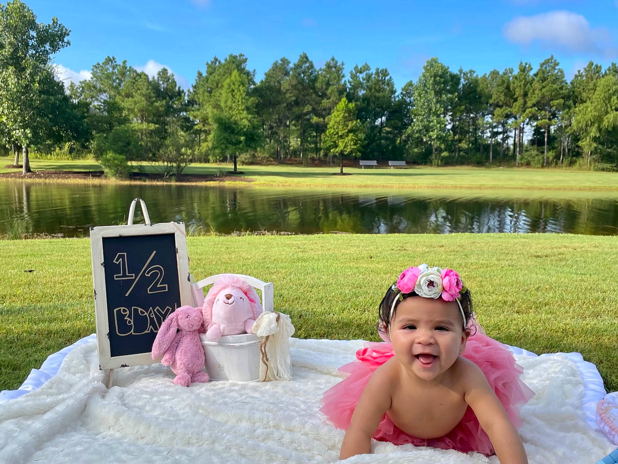 Leela is registered to the contest to win money with this photo: body_of_water, botany, grass, green, happy, hat, headwear, lake, leisure, mammal, nature, outdoor_recreation, people_in_nature, person, photograph, pink, plant, sky, sun_hat, tree