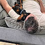 Milo joined the competition — help win amazing prizes! man, dog, couch, living_room, relaxing, pet, casual_clothing, phone, pillow, shorts, white_shirt, gray_hair, black_brown_dog, collar, indoor, carpet, wooden_furniture, resting, comfort, snuggling