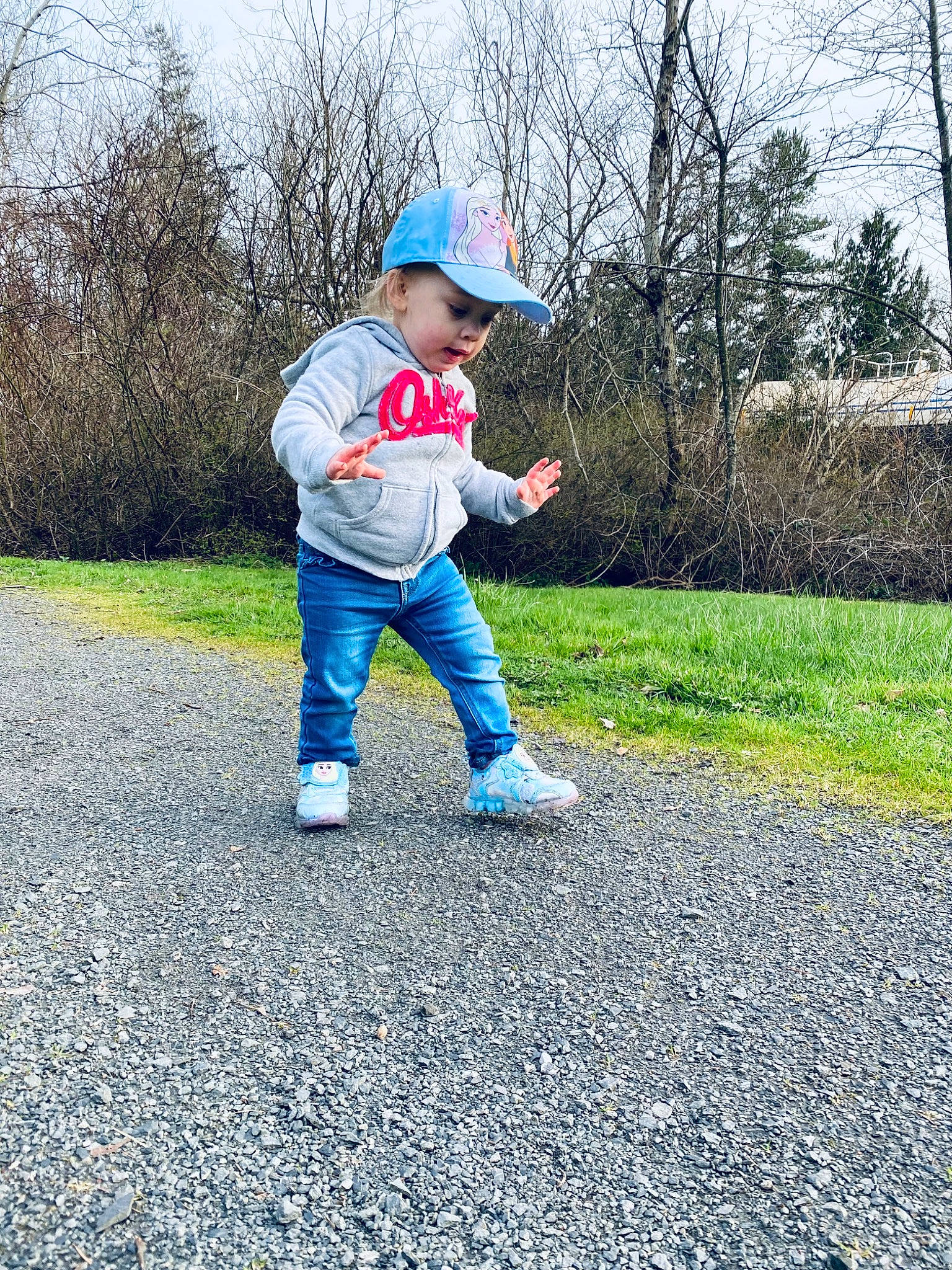 Delilah is registered to the contest to win money with this photo: asphalt, baby_toddler_clothing, cap, child, electric_blue, fun, grass, hat, headwear, landscape, people_in_nature, person, plant, recreation, road, road_surface, rolling, sky, sleeve, soil