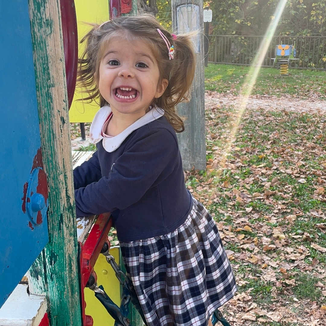 Laura participe au concours pour gagner de l'argent avec cette photo : autumn, child, climbing, daylight, dress, excited, fun, girl, happy, leaves, nature, outdoor, park, pigtails, play_equipment, playground, sandals, smiling, sunlight, trees