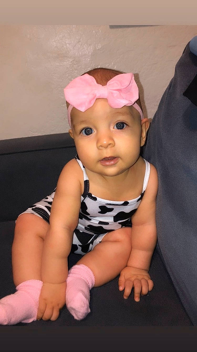 Ellamarie is registered to the contest to win money with this photo: baby, baby_toddler_clothing, cheek, eye, fashion_accessory, flash_photography, foot, fun, happy, headband, headgear, headwear, human_leg, magenta, pattern, person, purple, sitting, skin, sleeve