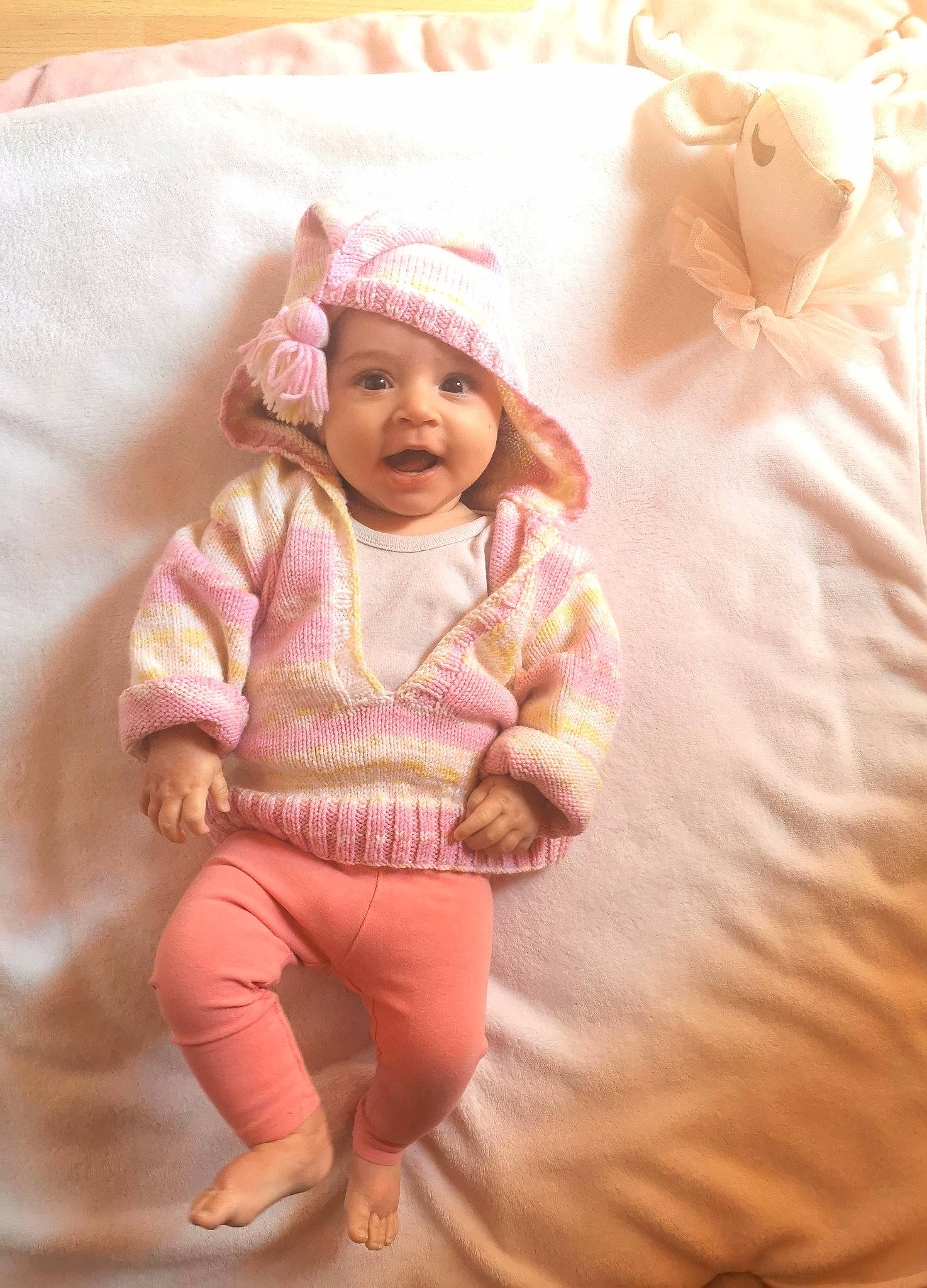 Luna a rejoint le concours — aidez-le/la à gagner de superbes lots ! baby, baby_toddler_clothing, cap, cheek, child, comfort, facial_expression, flooring, happy, headwear, linens, magenta, outerwear, pattern, peach, person, pink, skin, sleeve, smile