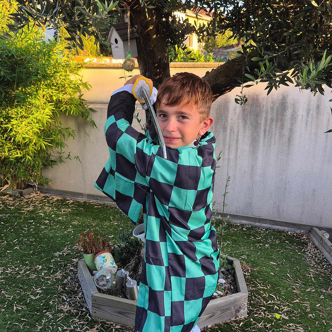 Naoki a rejoint le concours — aidez-le/la à gagner de superbes lots ! backyard, checkered, child, clothing, costume, fun, garden, grass, greenery, nature, outdoor, person, plant, play, pose, roleplay, shoes, sword, tree, young
