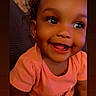 Alora is registered to the contest to win money with this photo: toddler, child, smiling, happy, face, portrait, curly_hair, peach_shirt, indoor, cute, baby, young_child, person, skin, eyes, mouth, earrings, expression, closeup, joy