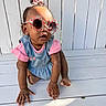 Alora is registered to the contest to win money with this photo: toddler, child, sunglasses, pink, denim, hair_bow, crouching, wooden_floor, white_background, outdoor, sunlight, curly_hair, cute, fashion, casual_clothing, baby, shadow, person, portrait, accessories