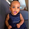 baby, child, girl, dress, navy_blue, pearl_belt, smiling, happy, sitting, chair, indoors, cute, skin, hair, earrings, portrait, expression, furniture, home, person