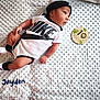 baby, infant, nike, clothing, blanket, milestone, month, plaque, name, textile, socks, hat, cute, portrait, lying_down, child, person, face, headwear, soft