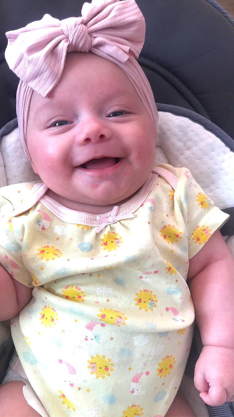 Mayzie a rejoint le concours — aidez-le/la à gagner de superbes lots ! baby, baby_laughing, baby_toddler_clothing, cheek, chin, dress, eye, face, fun, happy, head, headwear, lip, nose, person, pink, plant, skin, sleeve, smile