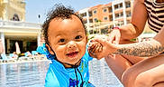 Kylo joined the competition — help win amazing prizes! toddler, child, smiling, swimsuit, blue, pool, water, tattoo, adult, holding_hands, outdoor, sunny, resort, building, vacation, happy, curly_hair, person, summer, playful