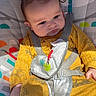 animal_print, baby, baby_seat, baby_toys, child, child_care, colorful, cute, elephant, indoors, infant, monkey, patterned_clothing, playful, portrait, seatbelt, sitting, soft_toys, sunlight, yellow_onesie