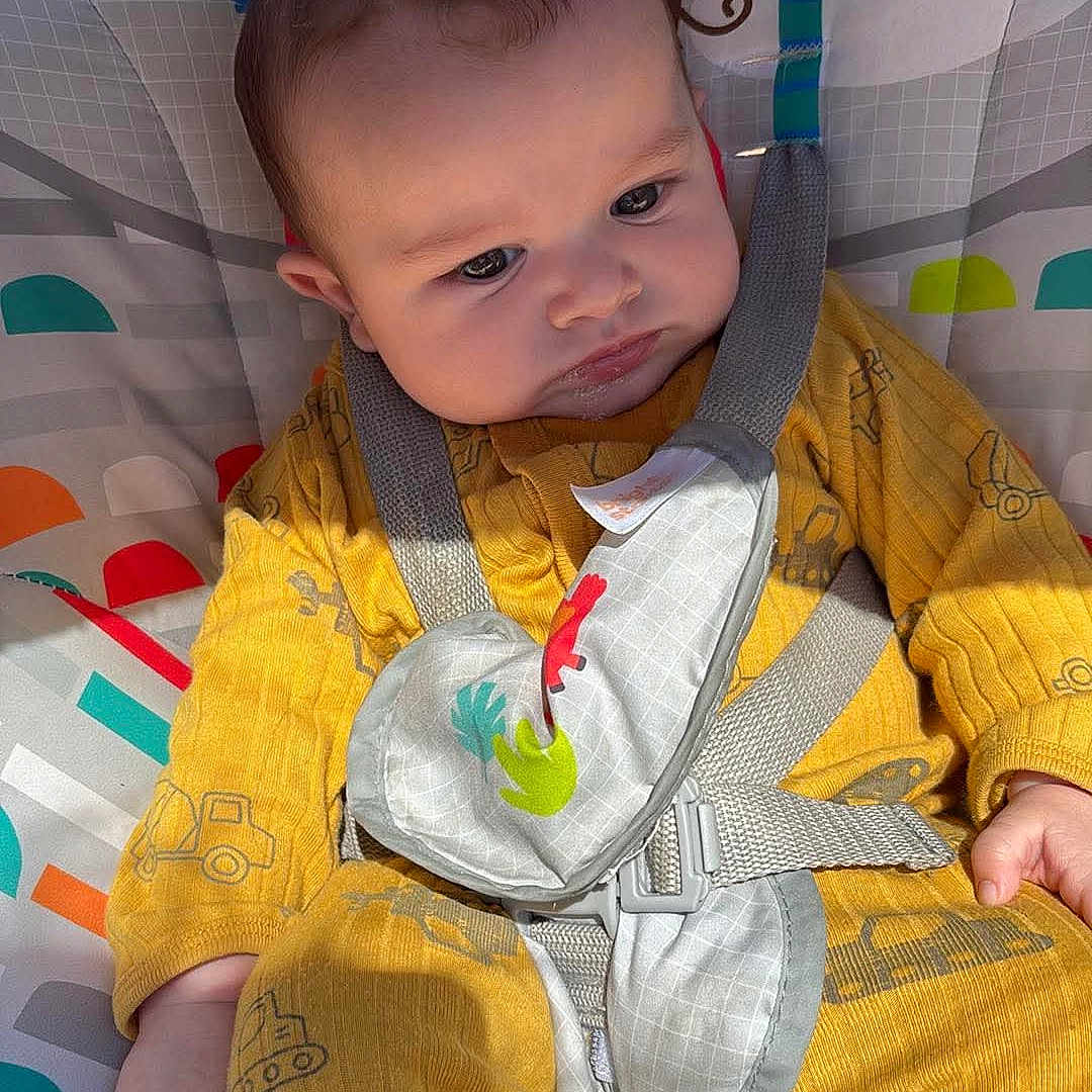 Josiah joined the competition — help win amazing prizes! baby, infant, yellow_onesie, baby_seat, animal_print, monkey, elephant, sunlight, child, cute, seatbelt, playful, indoors, colorful, patterned_clothing, soft_toys, portrait, baby_toys, child_care, sitting