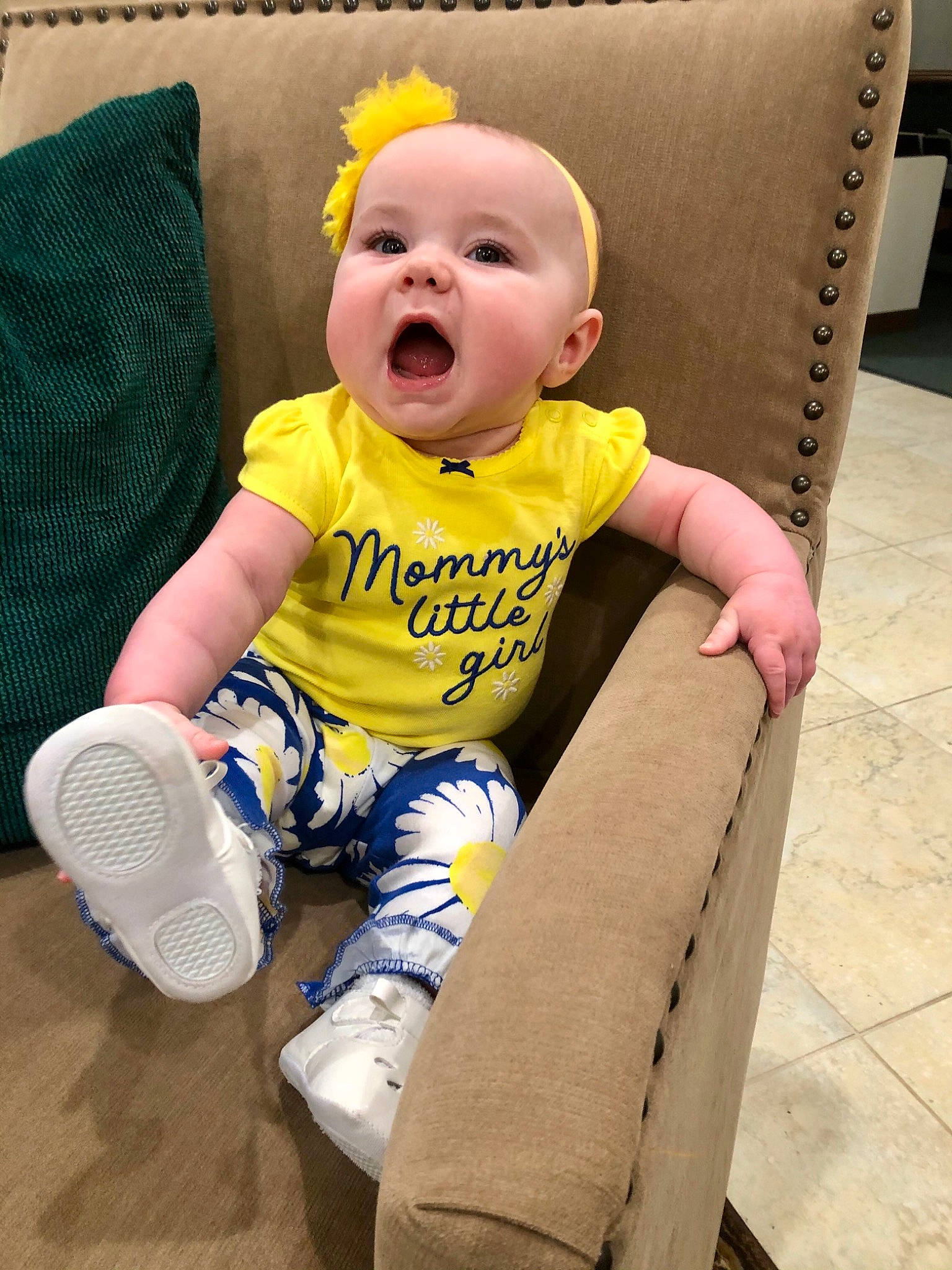 Stephanie is registered to the contest to win money with this photo: baby, baby_products, baby_toddler_clothing, chair, cheek, child, comfort, couch, eye, flooring, fun, happy, head, knee, person, sitting, sleeve, smile, t_shirt, thigh