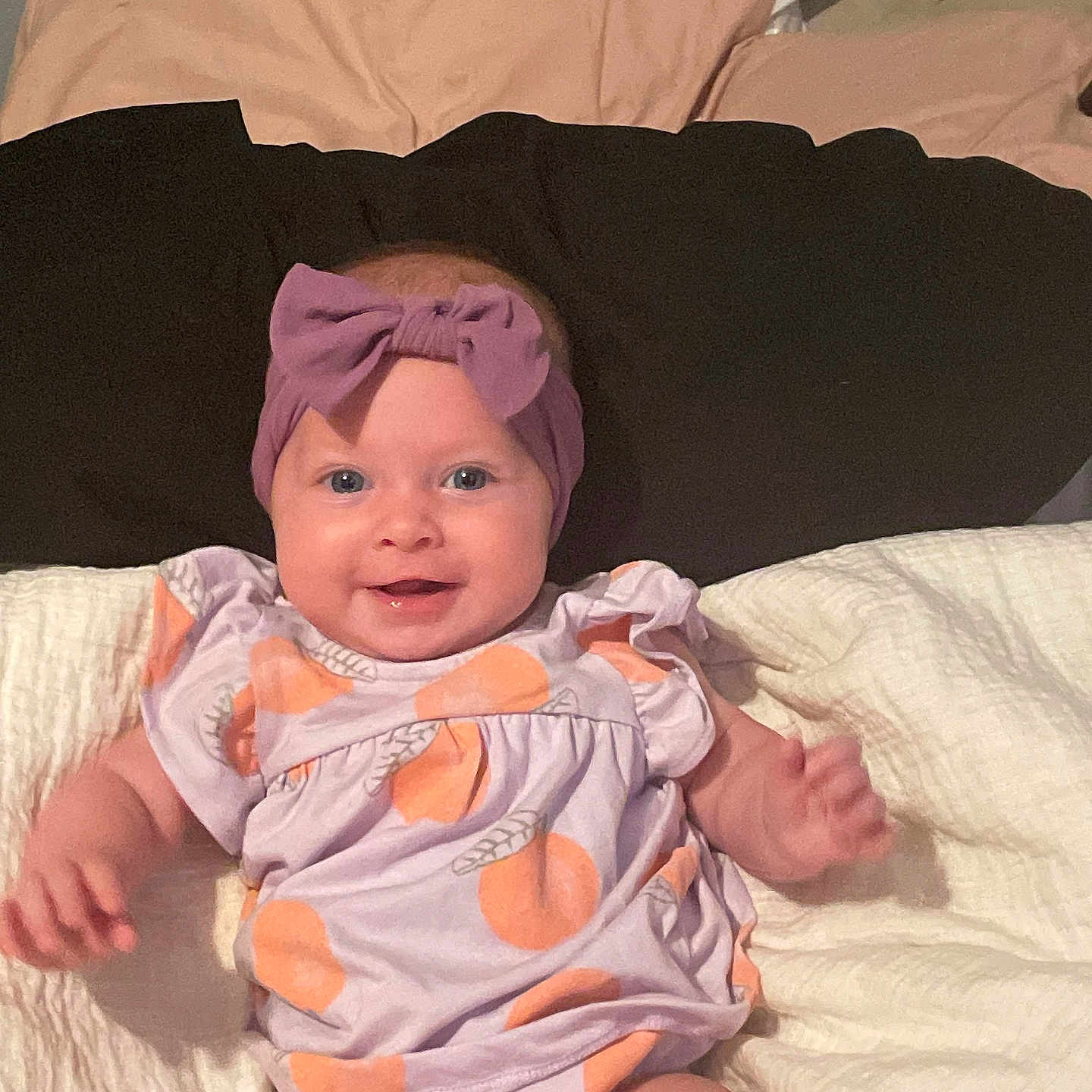 Everley joined the competition — help win amazing prizes! baby, bed, blanket, child, clothing, cute, face, happy, headband, indoors, infant, lying_down, orange_prints, person, pillow, portrait, purple_bow, skin, smiling, soft_lighting