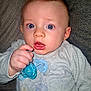 Ayden participe au concours pour gagner de l'argent avec cette photo : baby, infant, pacifier, blue, hand, face, eyes, clothing, onesie, expression, surprised, indoor, portrait, child, skin, person, couch, texture, closeup, holding