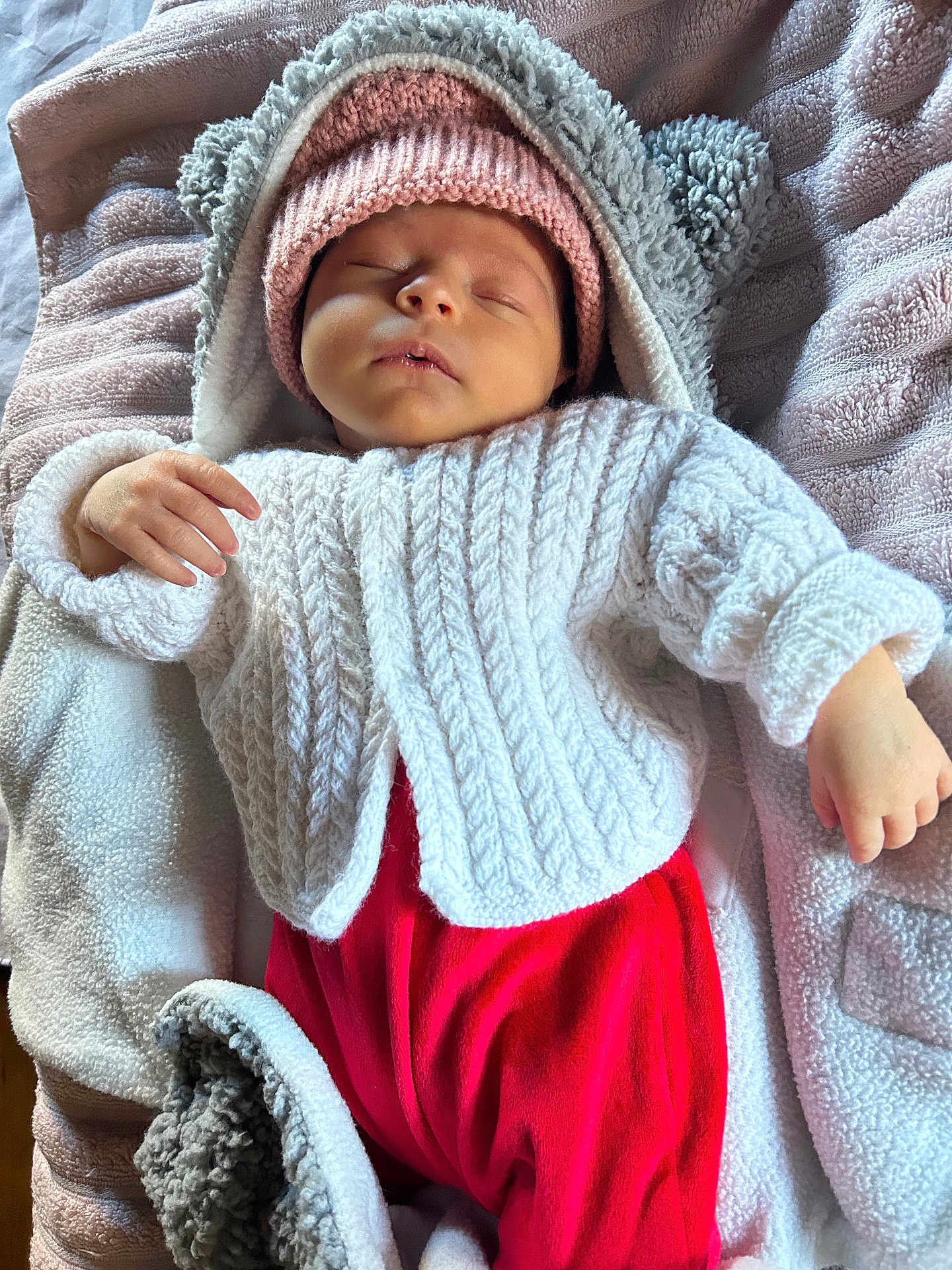 Maya participe au concours pour gagner de l'argent avec cette photo : baby, beanie, blanket, bonnet, cap, clothing, face, happy, hat, head, hood, hoodie, knitwear, newborn, person, photography, portrait, sleeping, sweater, sweatshirt
