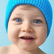 Mayron participe au concours pour gagner de l'argent avec cette photo : baby, child, blue_eyes, smile, hat, knit_hat, portrait, close_up, happy, cute, infant, skin, face, blue_background, headwear, young_child, expression, teeth, cheeks, indoors
