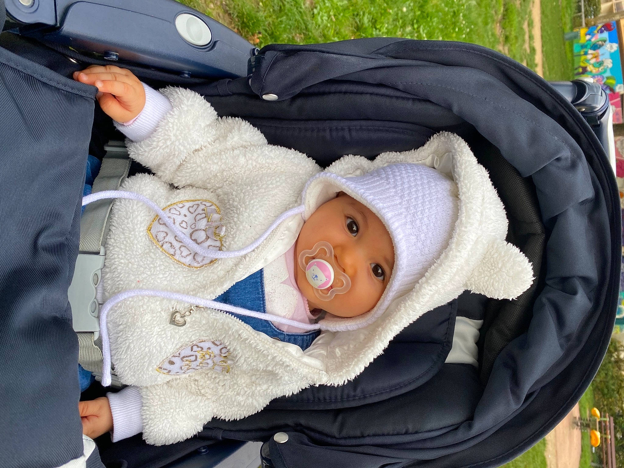 Selenia participe au concours pour gagner de l'argent avec cette photo : auto_part, baby, baby_carriage, baby_products, baby_safety, baby_toddler_clothing, bag, car_seat, child, comfort, grass, hat, headgear, headwear, person, plant, smile, sun_hat, toddler, tree