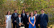 Aston a rejoint le concours — aidez-le/la à gagner de superbes lots ! dog, people, group_portrait, outdoor, sunny, blue_sky, trees, garden, formalwear, suits, dresses, friends, family, smiling, standing, leash, cream_dog, pavement, house, daylight