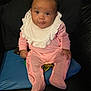Amara-Mae joined the competition — help win amazing prizes! baby, infant, pink_outfit, white_bib, cushion, blue_cushion, dark_background, sitting, looking_at_camera, portrait, cute, child, indoors, clothing, footed_pajamas, smiling, young_child, person, face, happy