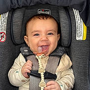 Matthias joined the competition — help win amazing prizes! baby, child, infant, smiling, happy, car_seat, safety_harness, pacifier, toy, sitting, portrait, face, eyes, hands, clothing, long_sleeves, vehicle_interior, padded_seat, closeup, photograph