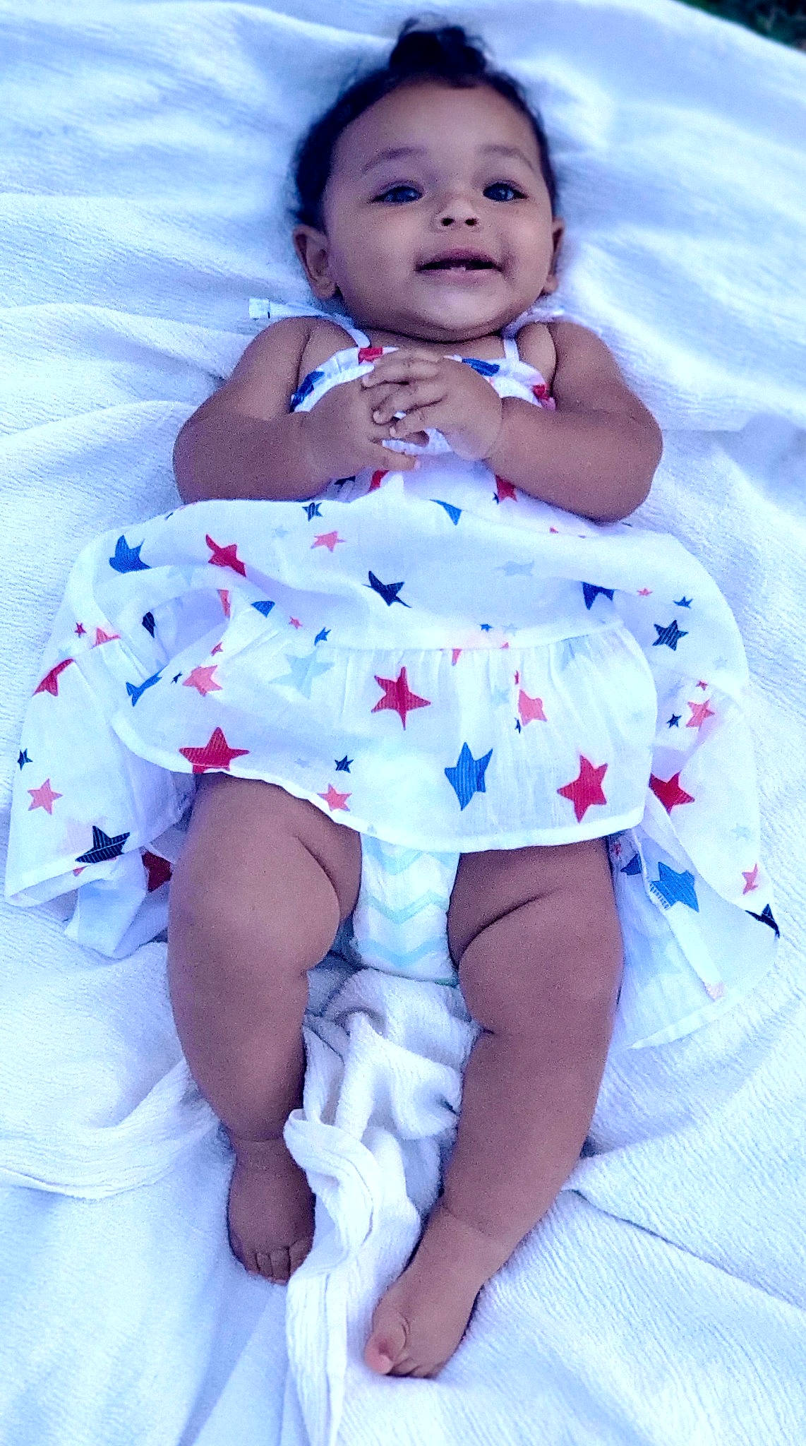 Paisley is registered to the contest to win money with this photo: arm, baby_toddler_clothing, blue, dress, eye, face, finger, flash_photography, happy, iris, leg, person, petal, pink, purple, skin, sleeve, smile, thigh, white