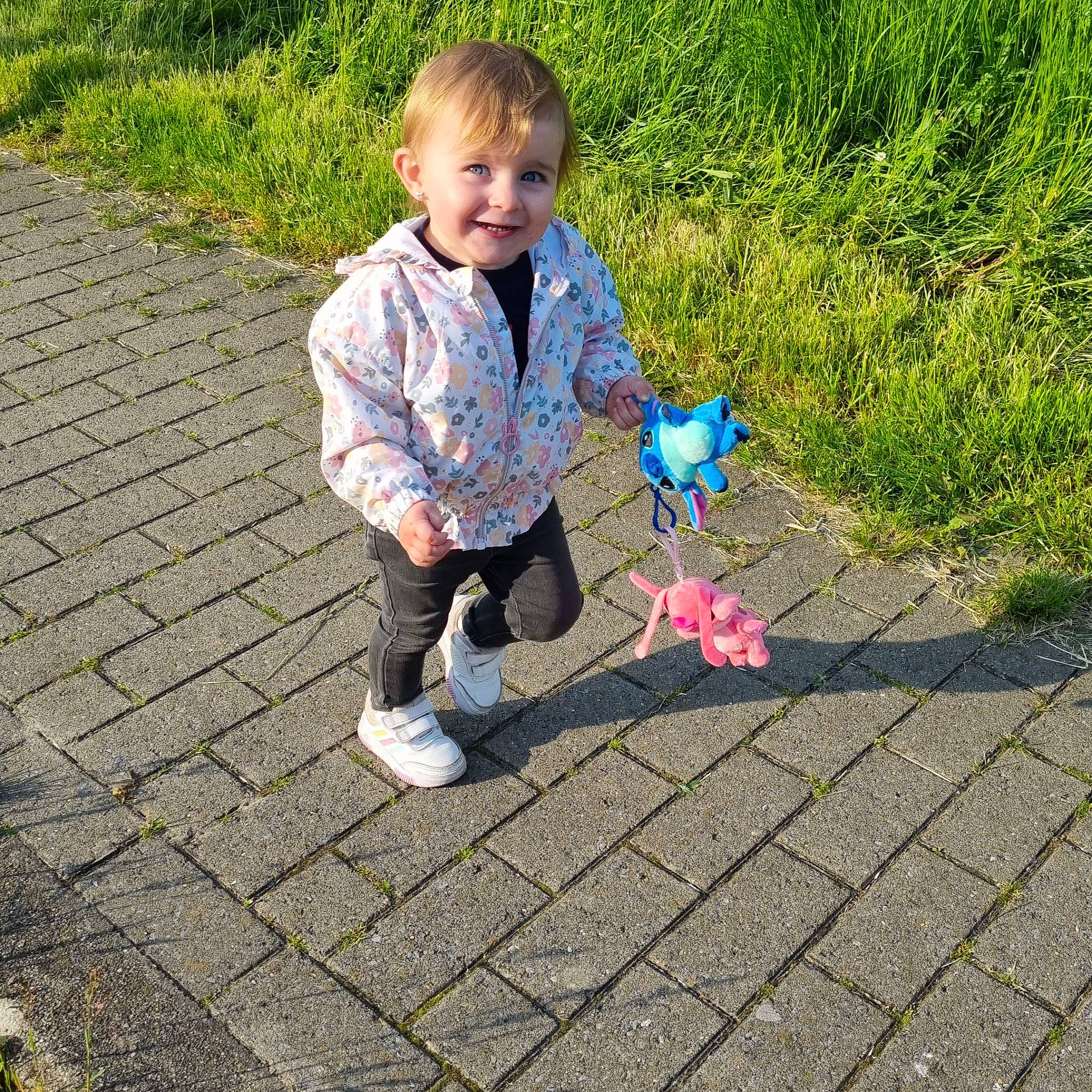 Théanna a rejoint le concours — aidez-le/la à gagner de superbes lots ! baby_toddler_clothing, child, electric_blue, fun, grass, happy, joy, leisure, pattern, people_in_nature, person, petal, plant, recreation, road_surface, sidewalk, sitting, smile, soil, toddler