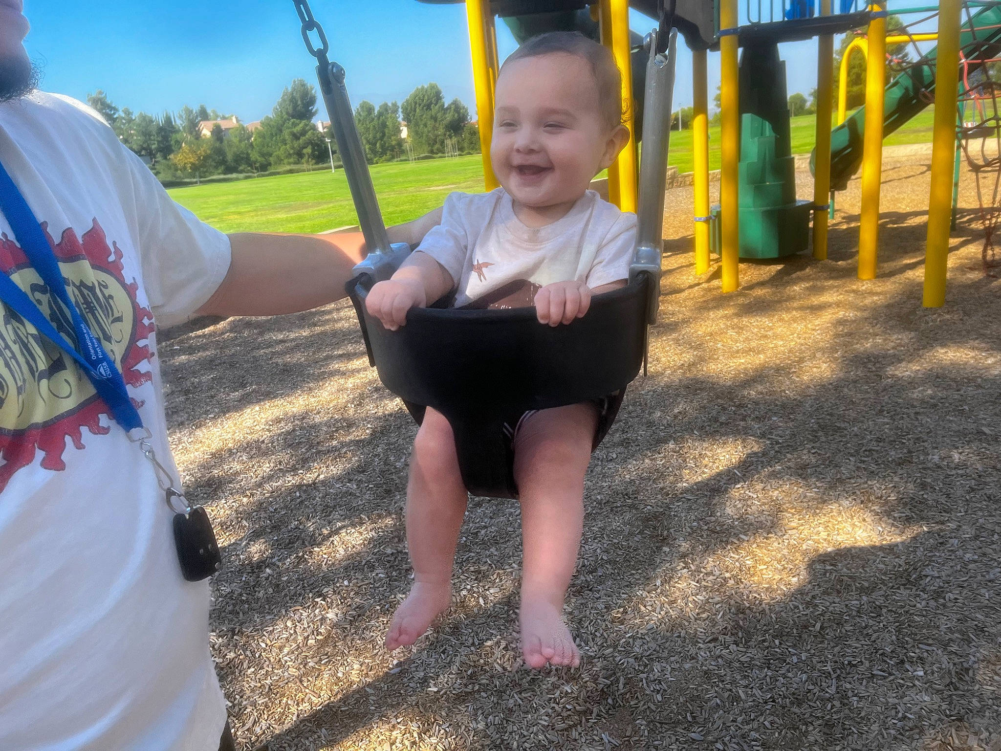Ezekiel is registered to the contest to win money with this photo: child, city, event, fun, gesture, grass, happy, joy, leisure, outdoor_play_equipment, person, plant, play, playground, recreation, sky, smile, soil, swing, t_shirt