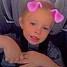 child, car_seat, face, blue_eyes, pink_ears_filter, hands, seatbelt, car_interior, tshirt, blond_hair, cute, portrait, young_child, smile, digital_filter, car_window, seat, casual_clothing, indoors, baby