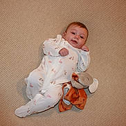 Brianna joined the competition — help win amazing prizes! animal_print, baby, carpet, child, comfort, cozy, cute, elephant, indoor, infant, laying_down, onesie, person, plush_toy, relaxed, sleepy, smiling, soft_toy, texture, toddler