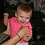 baby, blue_eyes, car_seat, cheerful, child, clothing, cute, hands, happy, holding, human, indoor, infant, person, pink_shirt, portrait, skin, smiling, tattoo, young_child