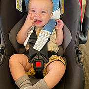 Matt is registered to the contest to win money with this photo: baby, infant, car_seat, smiling, happy, seatbelt, buckle, socks, legs, chubby_cheeks, hand, headrest, safety_tags, clothing, portrait, closeup, indoor, candid, toy, high_angle