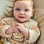 baby, child, smile, face, hands, clothing, cardigan, hello_kitty, seat, straps, cushion, indoor, cute, happy, infant, person, portrait, young_child, skin, expression