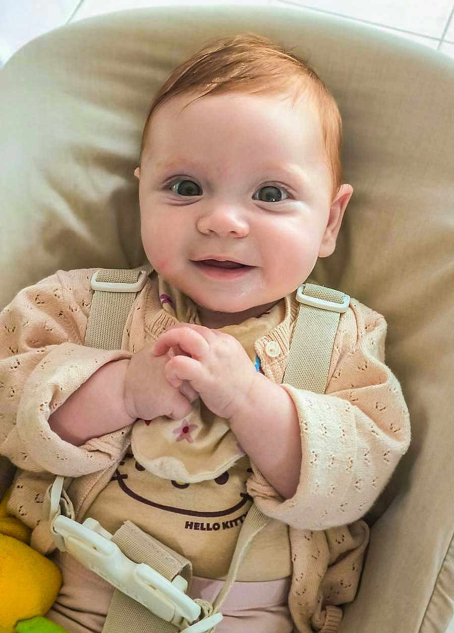Lilith participe au concours pour gagner de l'argent avec cette photo : baby, child, smile, face, hands, clothing, cardigan, hello_kitty, seat, straps, cushion, indoor, cute, happy, infant, person, portrait, young_child, skin, expression
