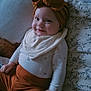 baby, child, smile, headband, bow, clothing, pants, onesie, bed, blanket, pattern, floral_pattern, happy, portrait, indoors, infant, cute, cozy, person, resting