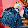 black_gown, chair, costume, dog, dress, dresser, fashionable, furniture, gold_hat, gown, hat, indoor, mirror, pet, pink_wall, poodle, portrait, sequins, sparkly, white_poodle