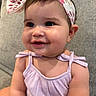 Stori joined the competition — help win amazing prizes! baby, child, girl, smile, face, headband, clothing, purple_dress, earrings, couch, furniture, indoors, skin, cute, happy, portrait, infant, head, person, closeup