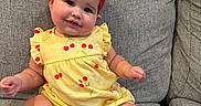 Stori joined the competition — help win amazing prizes! baby, child, infant, yellow_outfit, red_bow, chubby_cheeks, smile, couch, gray_couch, sitting, indoors, cute, happy, headband, barefoot, plush, portrait, one_person, young_child, comfortable