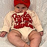 Stori is registered to the contest to win money with this photo: baby, infant, headband, red_bow, clothing, sitting, blanket, cute, child, face, legs, feet, hands, expression, portrait, indoors, soft_texture, comfortable, young, adorable