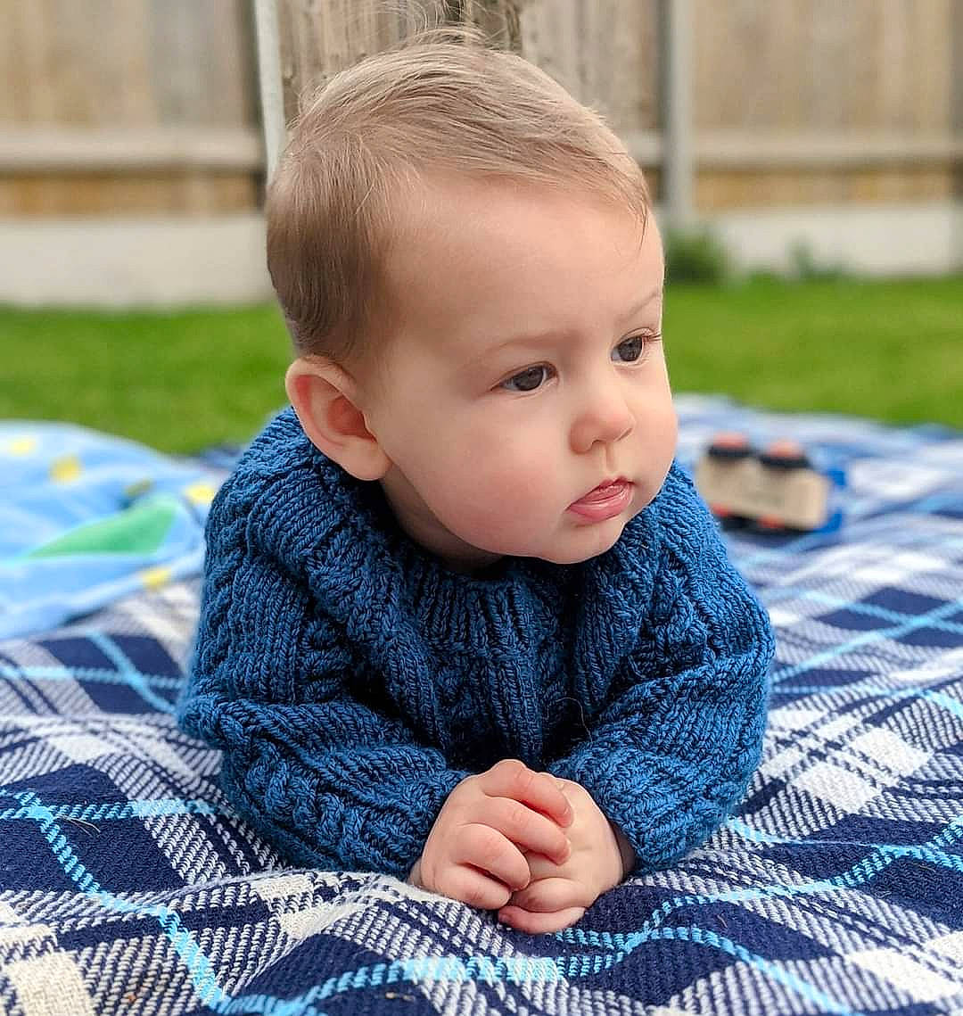 Oliver-james is registered to the contest to win money with this photo: baby, baby_toddler_clothing, blue, cheek, child, denim, electric_blue, flooring, fur, grass, happy, nose, pattern, person, plaid, sitting, skin, sleeve, tartan, toddler