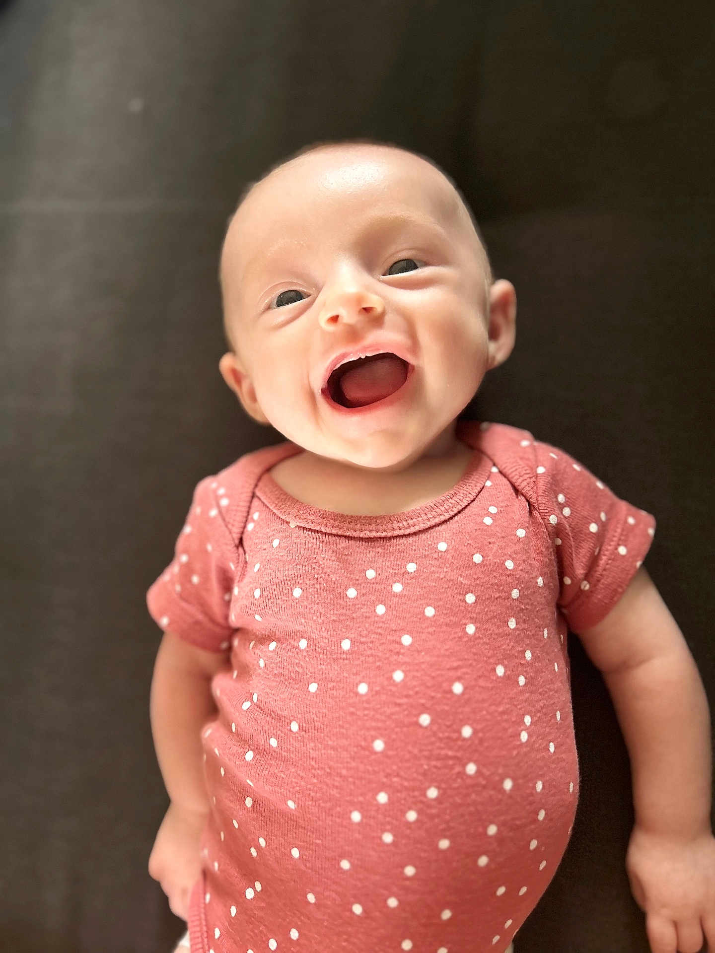 Miläya a rejoint le concours — aidez-le/la à gagner de superbes lots ! baby, smiling, infant, pink_onesie, polka_dot, happy, face, cute, child, portrait, young, human, skin, head, small_person, lying_down, expression, one_person, indoors, closeup