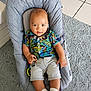 Maël participe au concours pour gagner de l'argent avec cette photo : baby, baby_seat, carpet, child, colorful_clothing, cute, dinosaur_pattern, face, hands, indoor, infant, legs, portrait, relaxed, shirt, shorts, smiling, socks, tile_floor, toddler